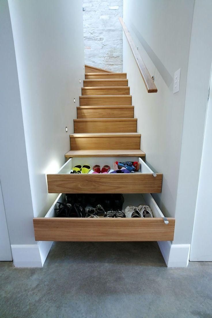 some shoes are sitting in the bottom drawer on this stair treading system that is built into the wall