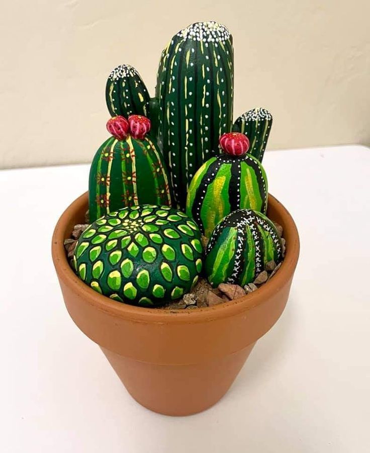 a potted plant with green and yellow painted cactuses in it's center