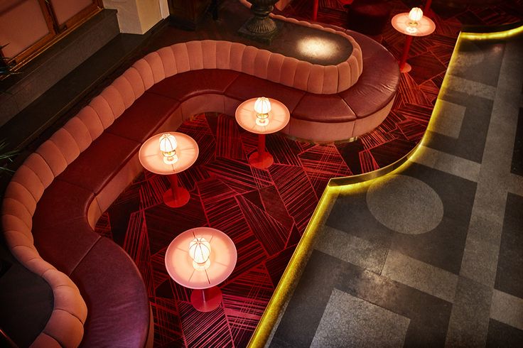 the interior of a restaurant with candles lit up on the tables and booths around it