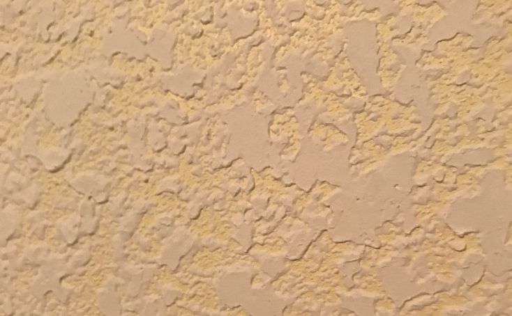 a close up view of the texture of a stucco wall with white paint on it