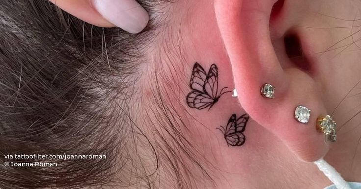 a woman's behind the ear tattoo with three butterflies on her left side piercing