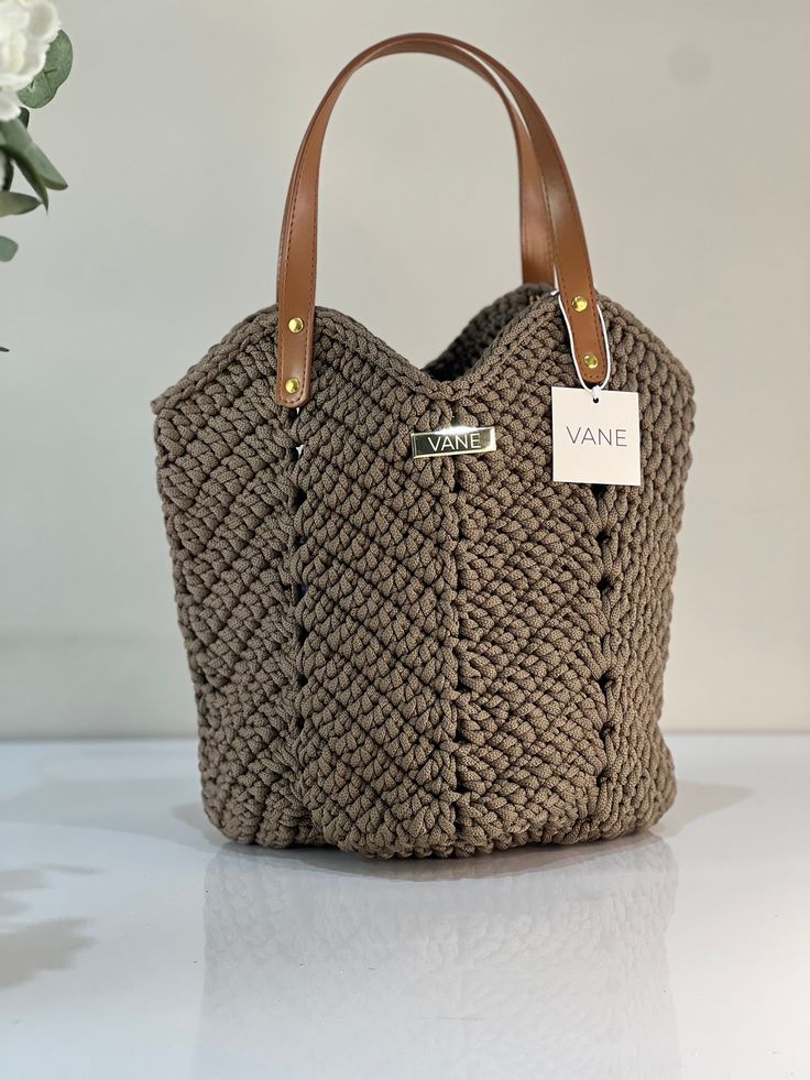 VANE Handmade Handbag Camila Crochet bag made of polyester yarn in the color mocha - Elegant leather handles for a modern touch - Elastic model - Dust bag, perfect for safe storage Dimensions: 25 x 32 cm Taupe Leather-handled Tote Shoulder Bag, Taupe Bags With Leather Handles For Daily Use, Modern Crochet Tote Bag For Shopping, Versatile Beige Rectangular Crochet Bag, Beige Bucket Bag With Braided Handles, Taupe Leather Handle Shoulder Bag For Travel, Light Brown Leather-handled Bucket Tote Bag, Light Brown Bucket Bag With Leather Handles, Light Brown Leather Handle Bucket Bag