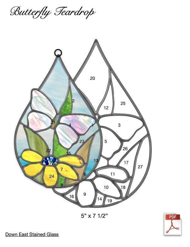 a stained glass window with flowers and leaves in the shape of a tear shaped drop