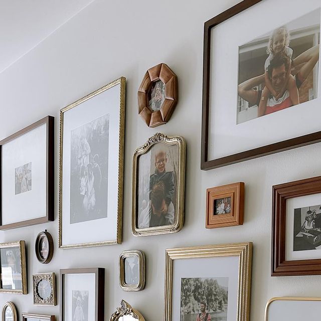 a wall with many frames and pictures on it