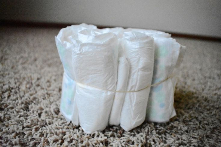 four rolls of toilet paper are stacked on top of each other in the middle of a carpeted room