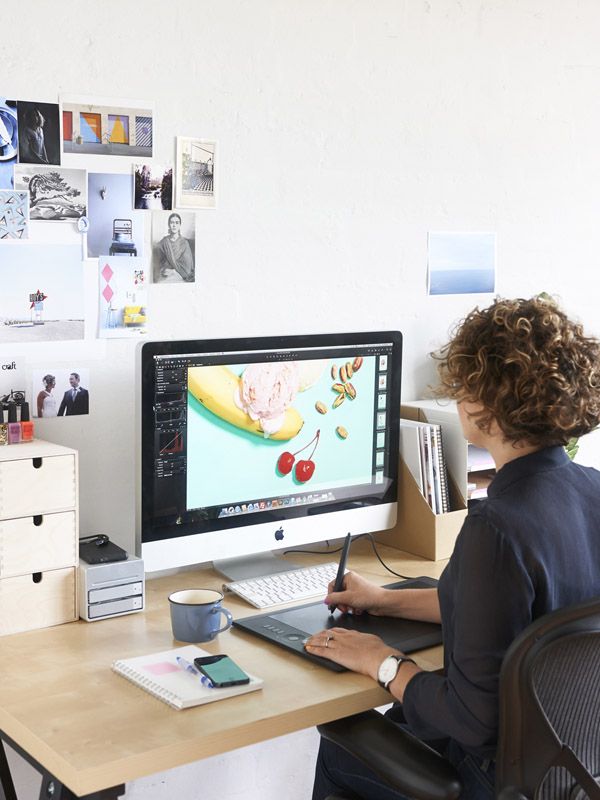 a woman sitting at a desk in front of a computer