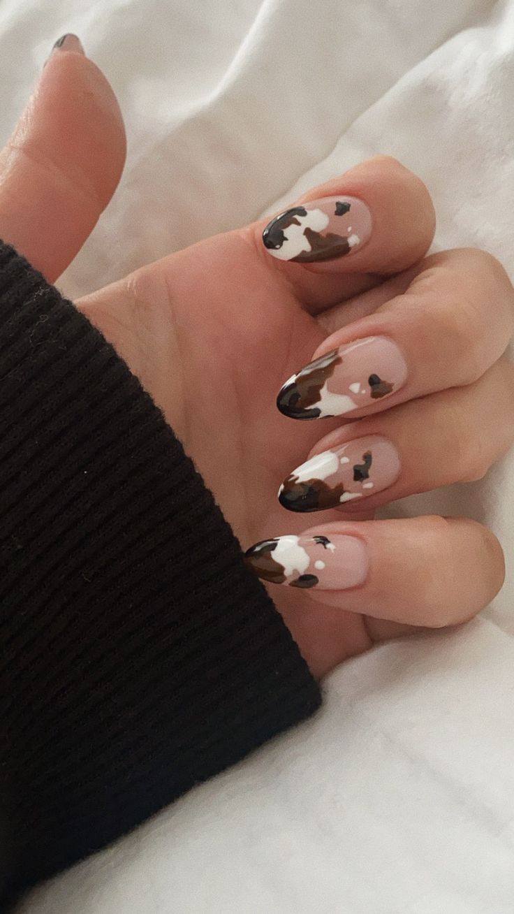 Cow Oval Nails, Cow Themed Nail Art, Glitter Nails With Nail Art, Nail Cow Designs, Cow Print Nails Matte, Short Nail Cow Designs, Cow Print Nails How To, Almond Acrylic Nails Cow Print, Cow Hide Nail Designs