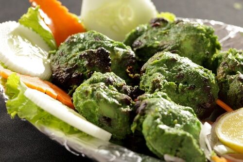 a plate filled with lettuce, carrots and meatballs covered in sauce