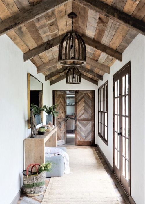 a hallway with wooden ceiling and white walls