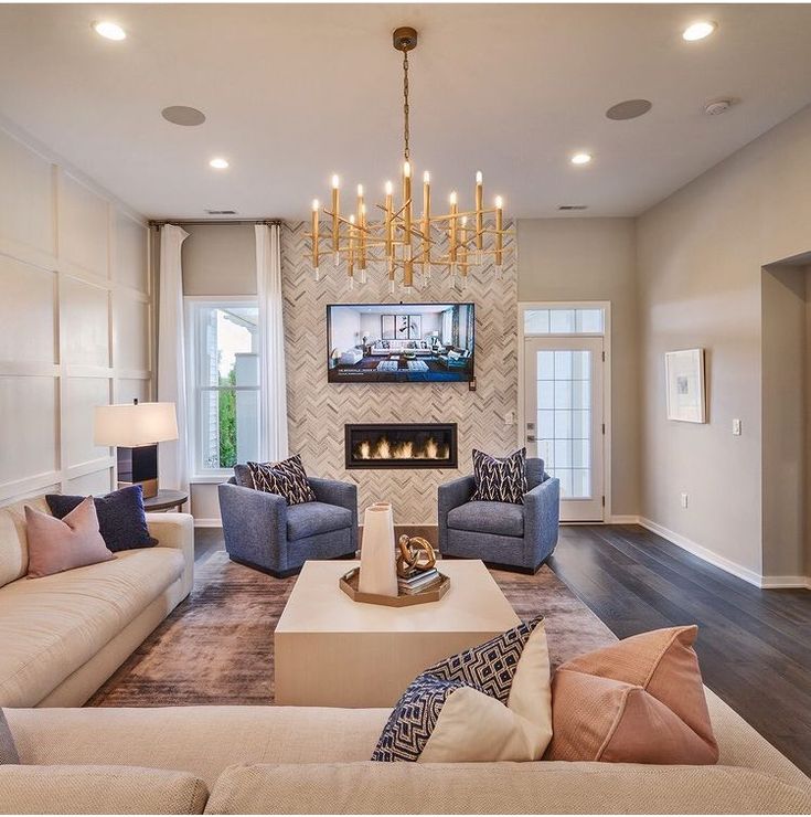 a living room filled with furniture and a flat screen tv mounted to the wall over a fireplace