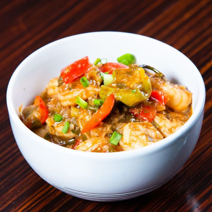 a white bowl filled with food on top of a wooden table