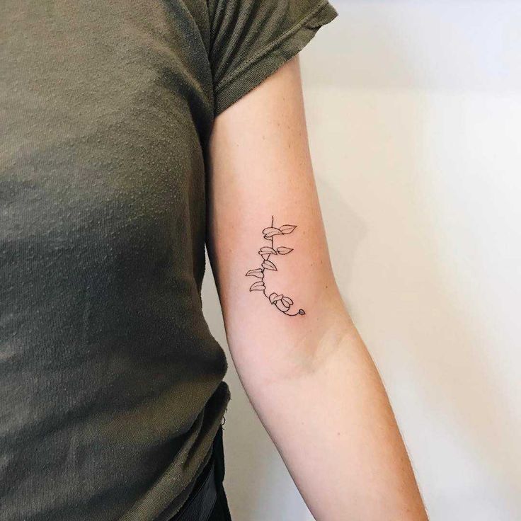 a woman's arm with a small tattoo on the left side of her arm