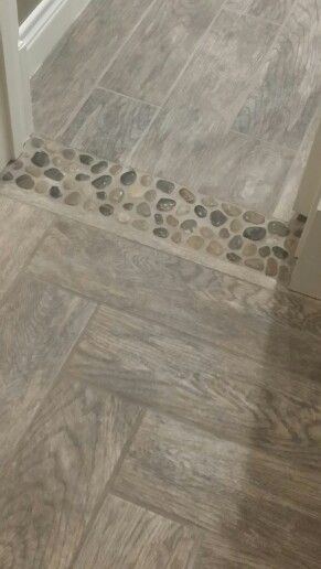 a bathroom with grey tile floors and white trimmings on the door way, next to a toilet