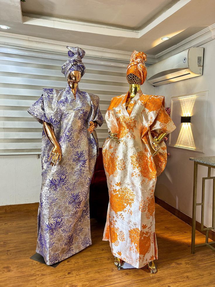 two women in colorful dresses standing next to each other on a hard wood flooring area