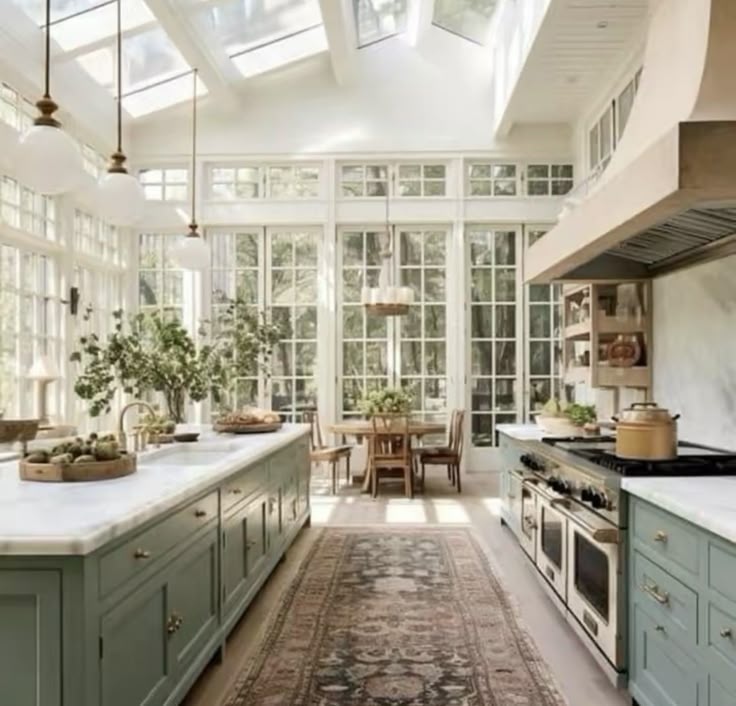 a kitchen filled with lots of green cabinets and white counter tops under a skylight