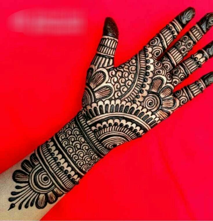 the hand is decorated with henna designs on it's fingers and hands, which are