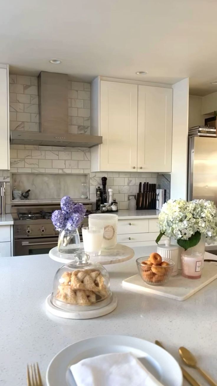 a kitchen counter with plates, cups and flowers on it in front of an oven