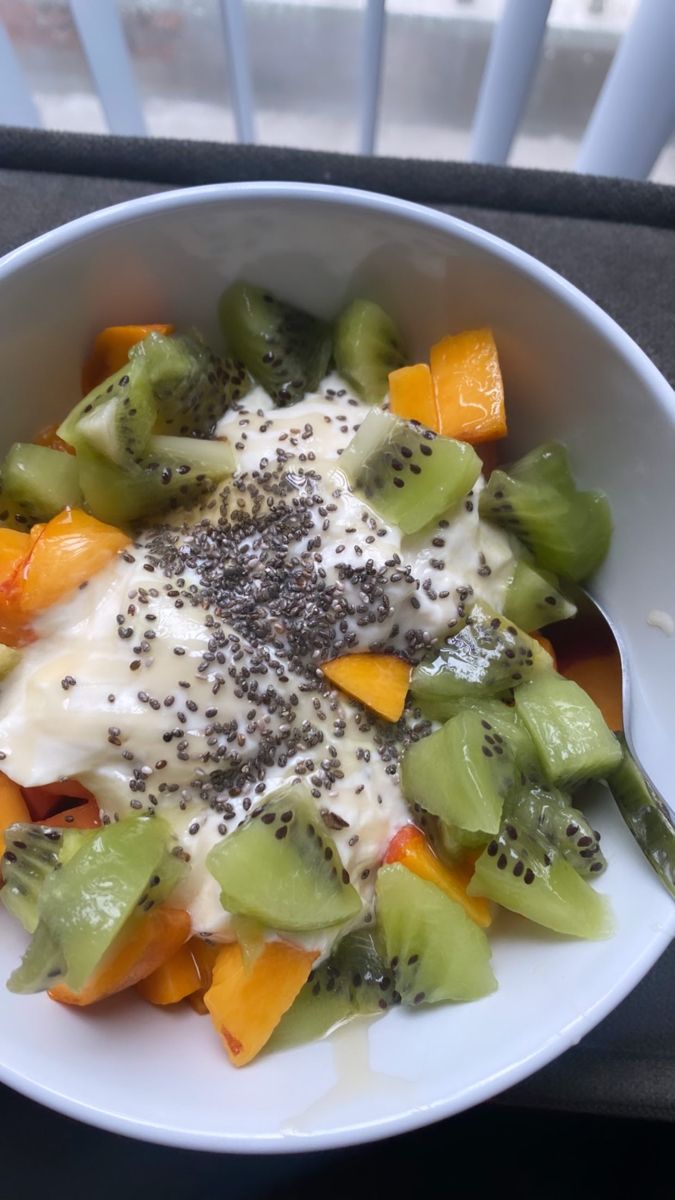 a white bowl filled with lots of different types of food on top of a table