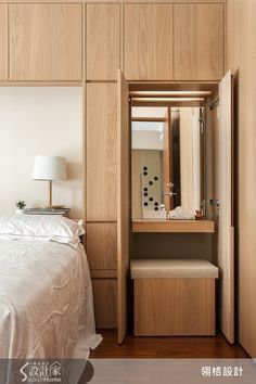 a white bed sitting in a bedroom next to a wooden wall