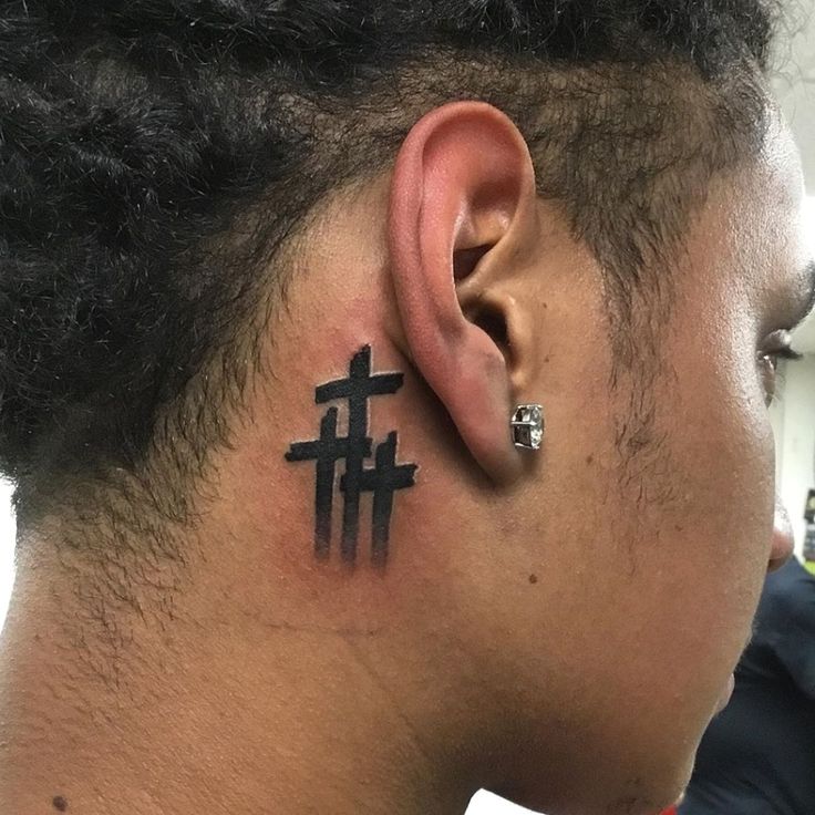 a man with a cross tattoo on his ear