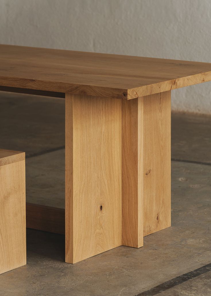 a wooden bench sitting on top of a cement floor