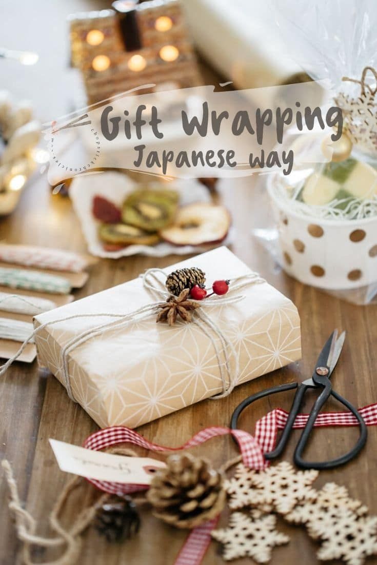 a gift wrapped in white paper sitting on top of a wooden table next to scissors