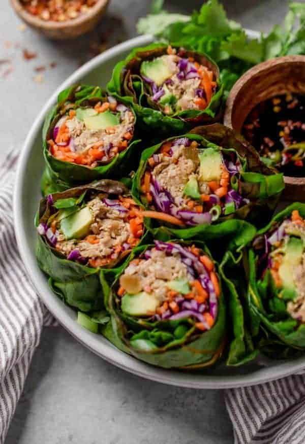 a white bowl filled with lettuce wrapped in meat and vegetables