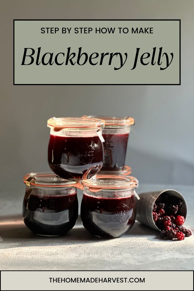 four jars filled with blackberry jelly sitting on top of a table