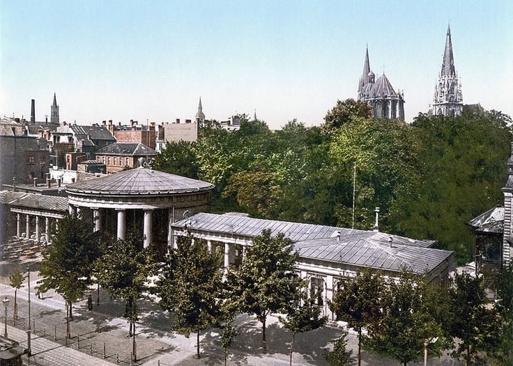 an aerial view of a city with tall buildings and trees in the foreground,