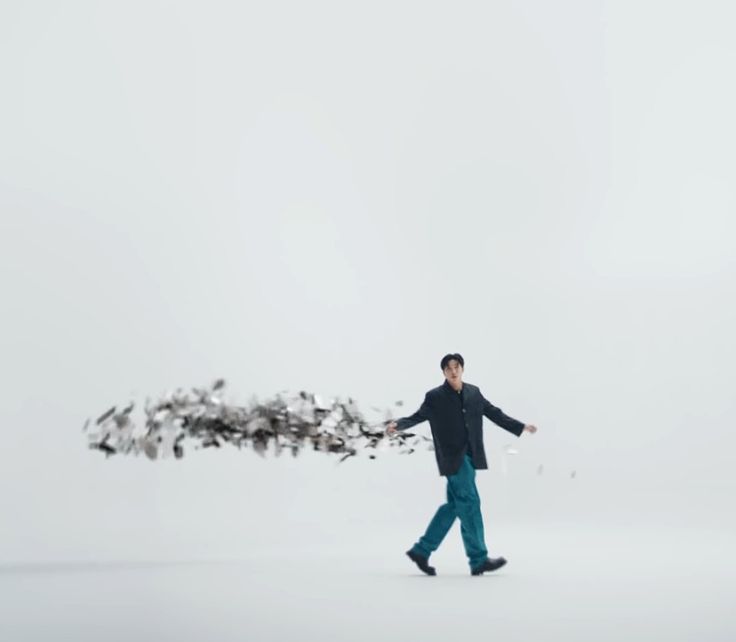 a man is walking in the snow with birds on his back and arms spread out