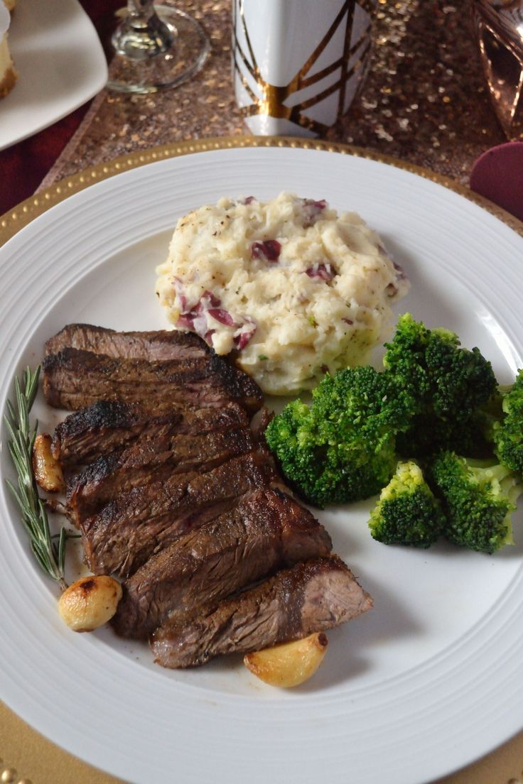 a white plate topped with steak, potatoes and broccoli