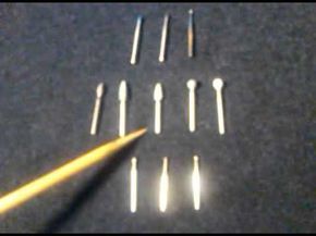 several different types of toothbrushes and needles on a table