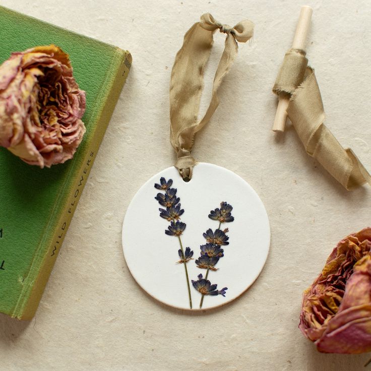 some dried flowers are sitting next to a book and an ornament on a table