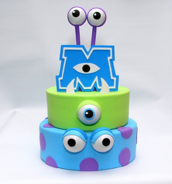 a three tiered cake decorated with monster eyes