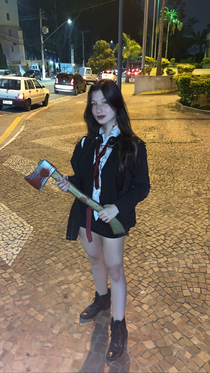 a woman in short shorts and tie holding a book on the side of a road