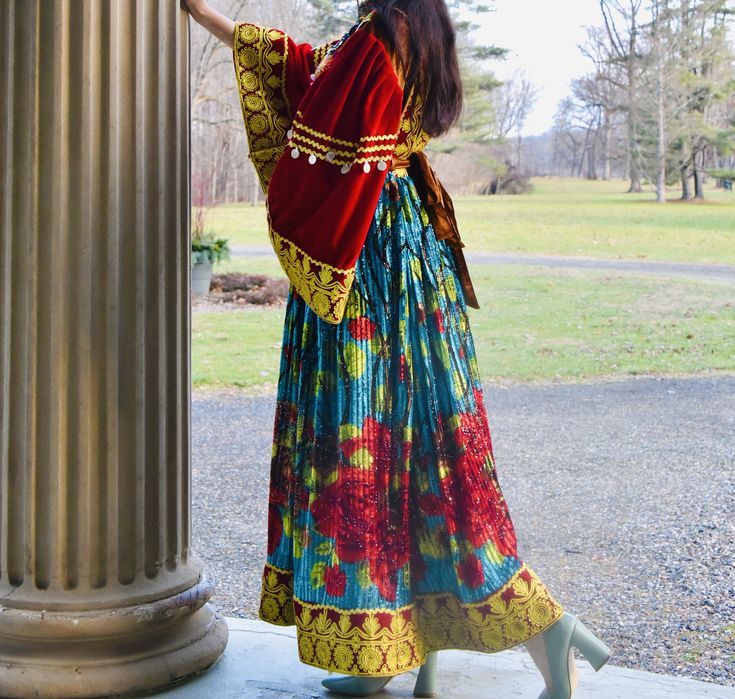 This dress is a colorful handmade piece for big sleeves lovers in Afghan dresses. This bright Colorful Afghan Dress with Matching Jewelry comes in red with detailed patterns in blue and gold on the skirt. It includes matching embroidered details and a set of traditional Afghan necklace. Great for cultural events and celebrations. The top front portion is all handicrafted by talented Afghan women. Traditional Afghanistan Clothing, Afghanistan Culture Traditional Dresses, Kuchi Afghan Dresses, Kochi Afghan Dress, Afgan Dress Afghani Clothes, Afghan Necklace, Afghan Women, Afghan Dress, Big Sleeves