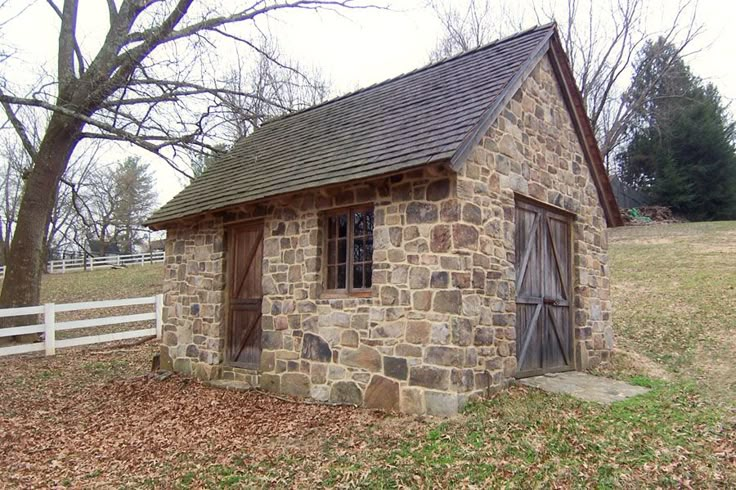 an old stone building sitting in the middle of a field