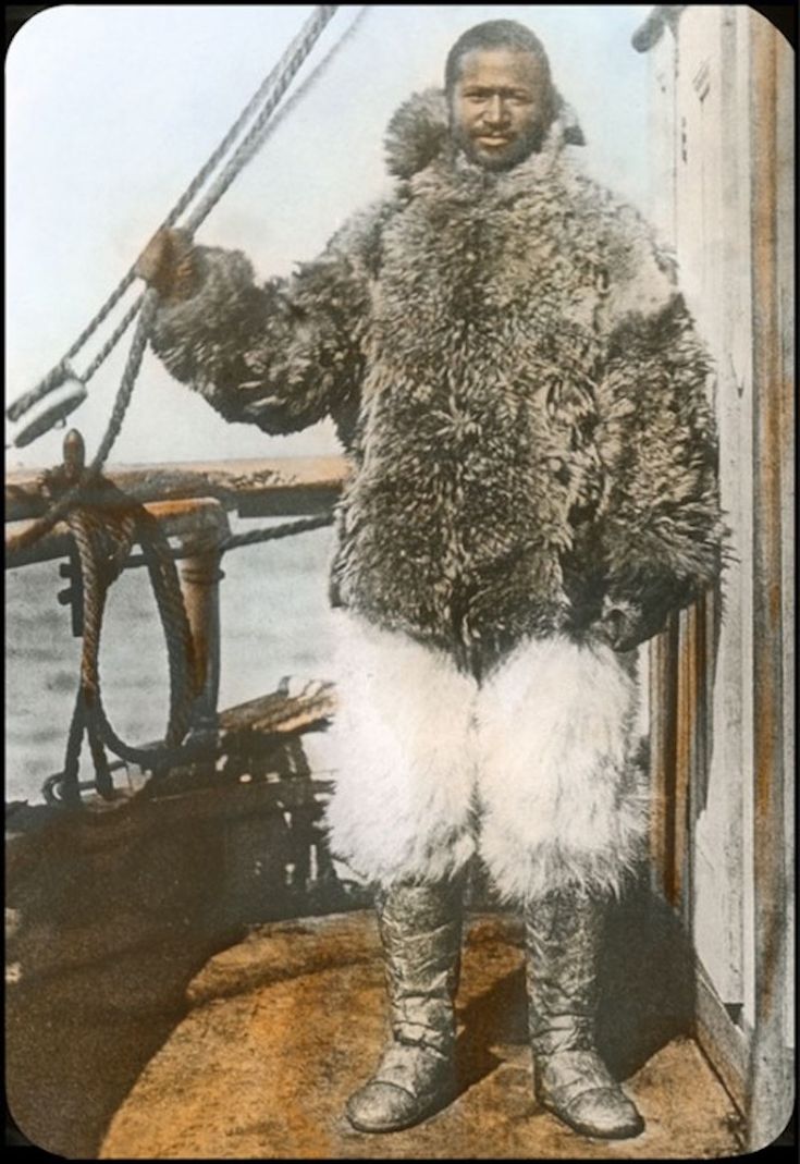 an old photo of a man in furs on a boat with the ocean behind him