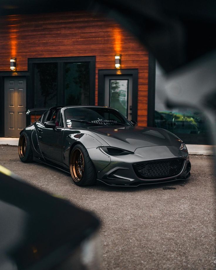 a black sports car parked in front of a building