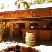 an outdoor patio area with barrels and tables