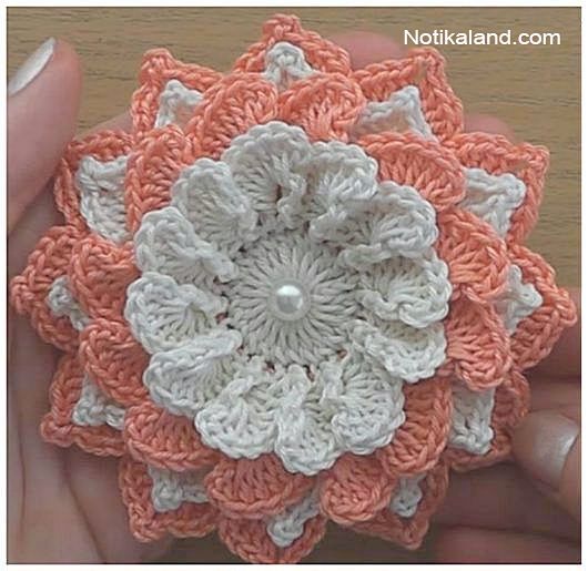 someone is holding a crocheted flower in their hand