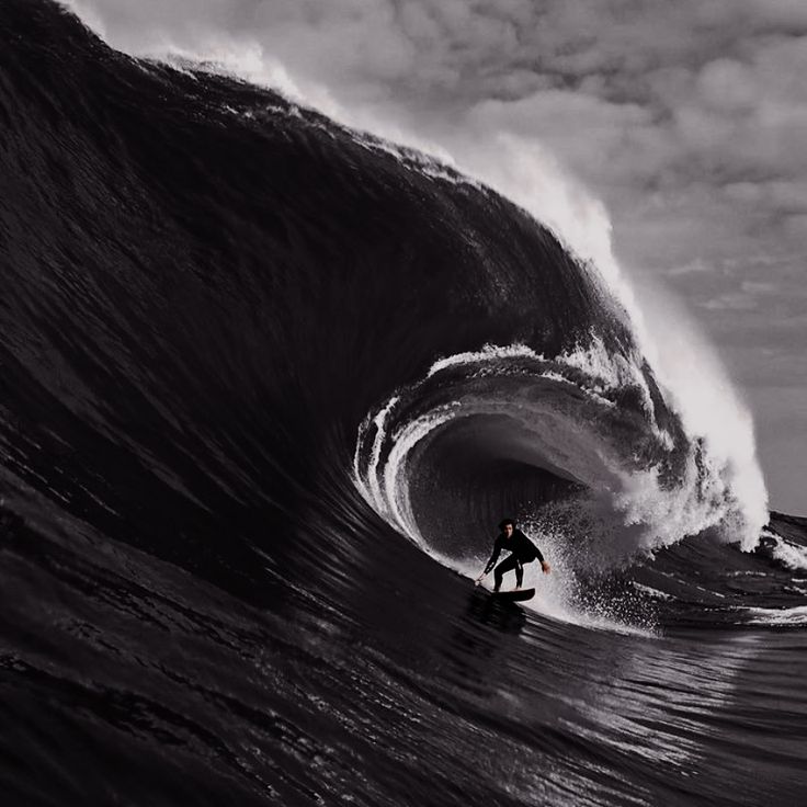 a man riding a wave on top of a surfboard