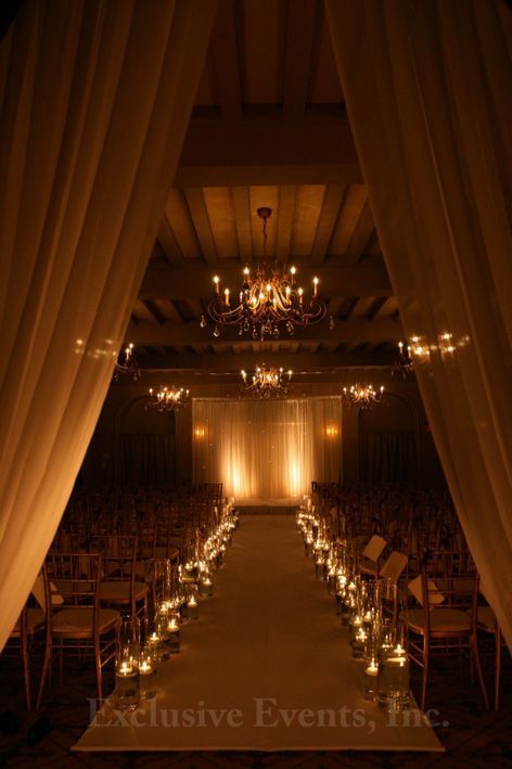 the aisle is lined with candles and chairs