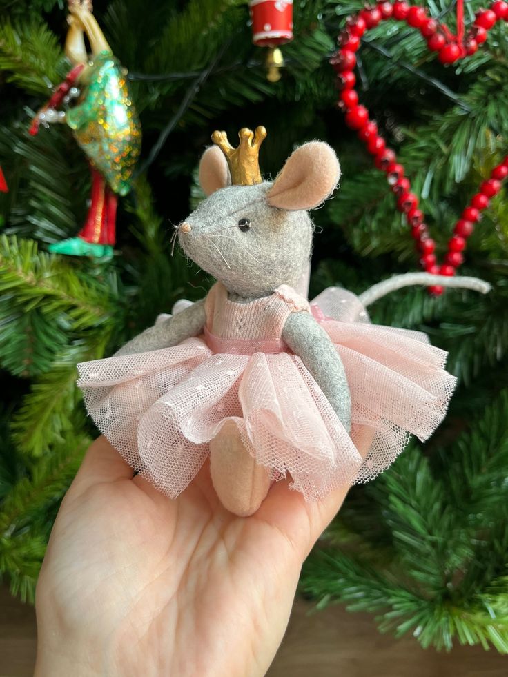 a small mouse in a pink tutu with a gold crown