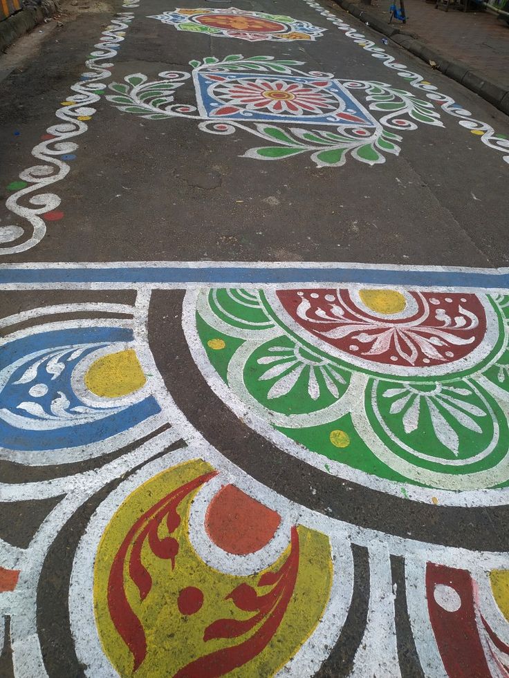 the sidewalk is painted with colorful designs on it