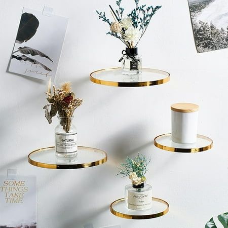 three shelves with vases and flowers on them against a white wall next to photos