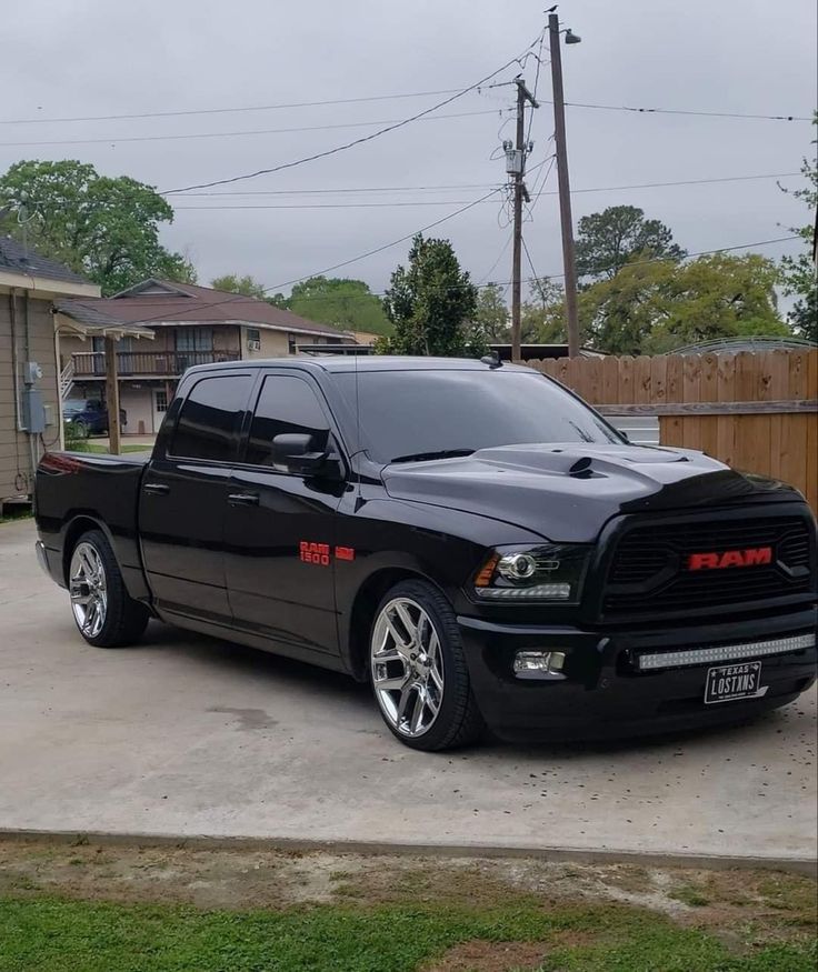 a black ram truck parked in a driveway