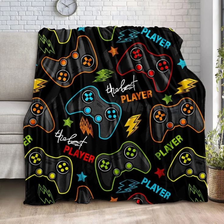 a couch with a blanket on it that has video game controllers all over the place