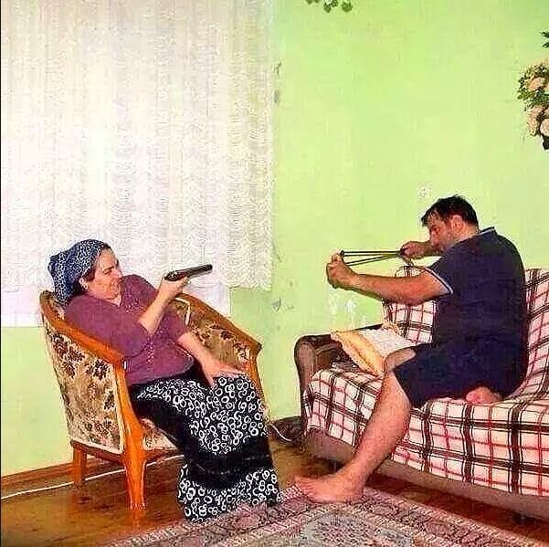 two people sitting on couches in a living room with rugs and green walls