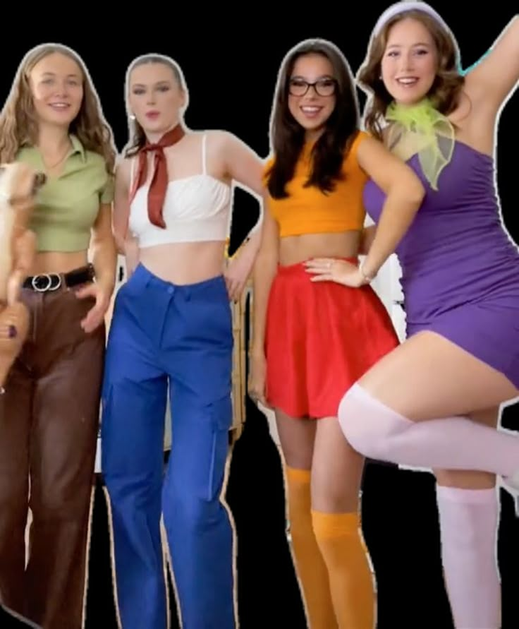 four women dressed up in costumes posing for a photo with their hands on the hips